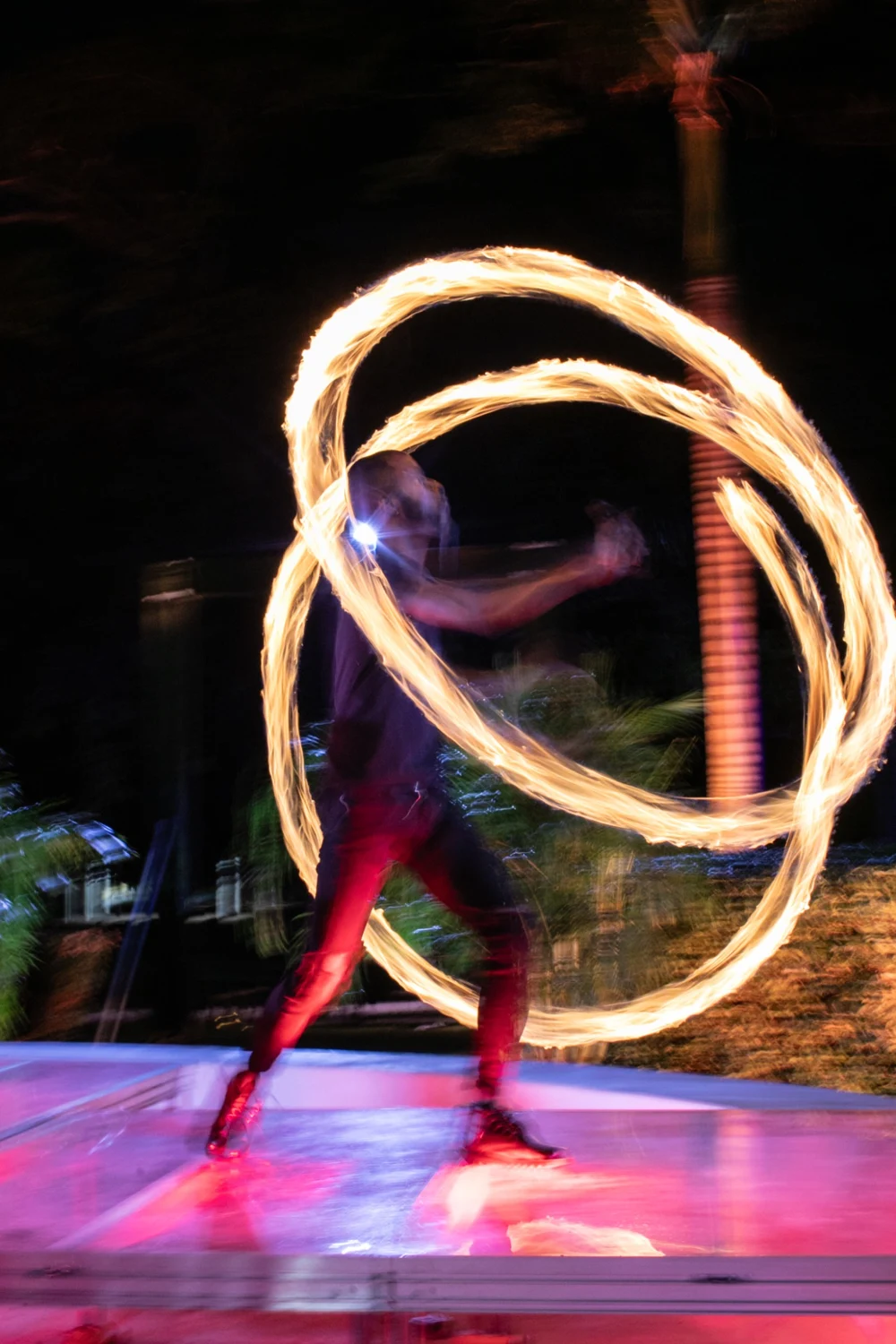 A male fire dancer weaving circles of fire at the 2026 Palm Noir Gala