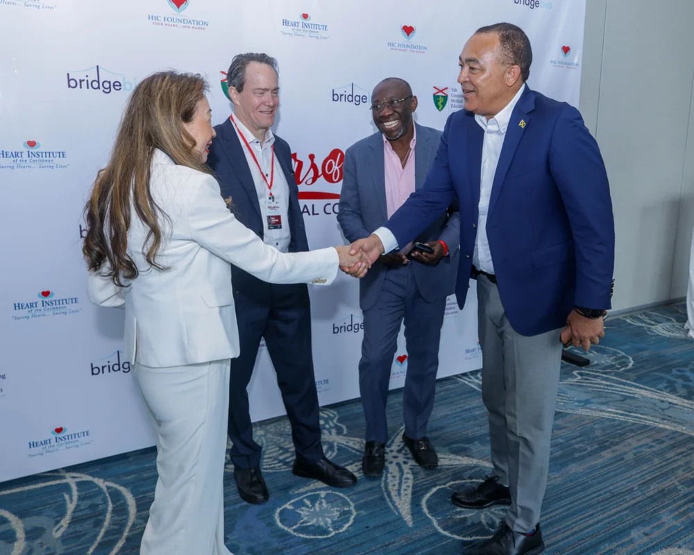 Conference participants meeting beside the Masters of Medicine backdrop